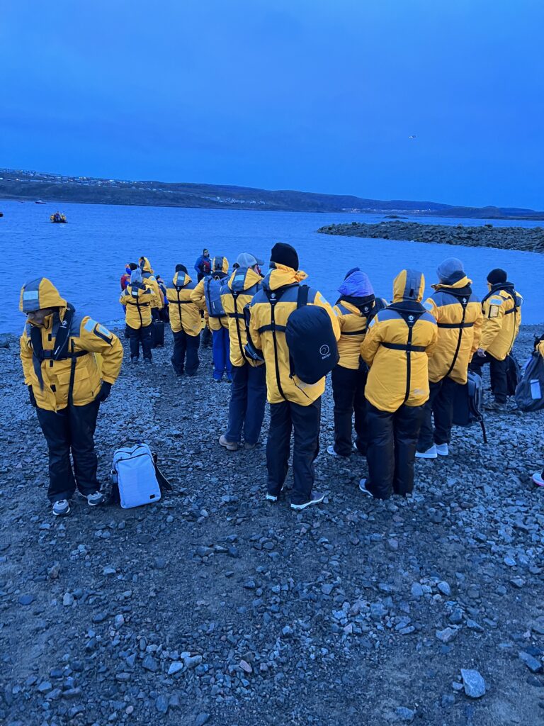 Passengers waiting on the beach in Iqaluit for the Zodiac transfer to Quark Expeditions Ultramarine.